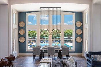 A dining room with a pool in the background.